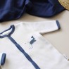 Close-up of the navy blue sleepsuit and swaddle pattern in the background