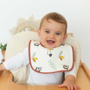 Bambino sorridente con il bavaglino sul seggiolone