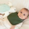 Bebè con la sua bavaglino verde oliva e il suo peluche tartaruga