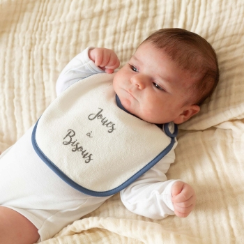 Baby mit seinem marineblauen Lätzchen um den Hals
