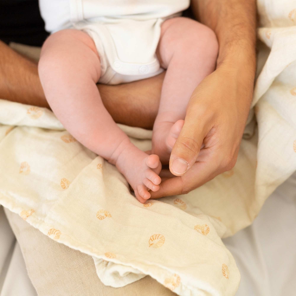 Papà che avvolge il bebè con il braccio