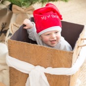 bebé juega en una caja de regalo de navidad con su gorro de navidad