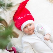 Baby mit seiner Weihnachtsmütze und seinem Kuscheltier