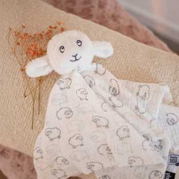 Puesta en escena del doudou oveja con un estampado all over sobre la tela