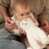 baby chewing on the ear of the musical sheep plush toy