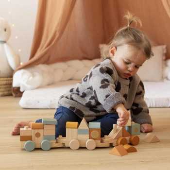 Baby playing with stackable wooden train