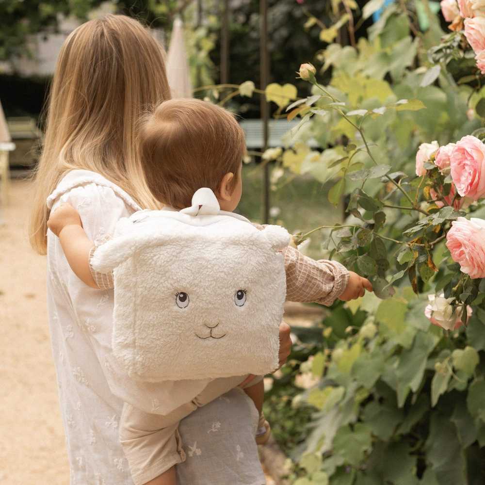 baby in de armen van mama met zijn rugzak