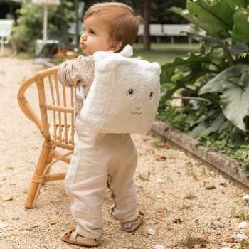 Baby läuft mit seinem Schaf-Rucksack