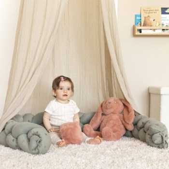 bébé joue avec son cube d'éveil assis entouré de sa tresse décorative