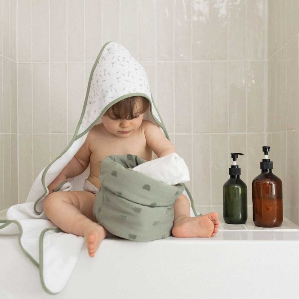 bébé à la sortie du bain avec sa sortie de bain et sa panière de toilette