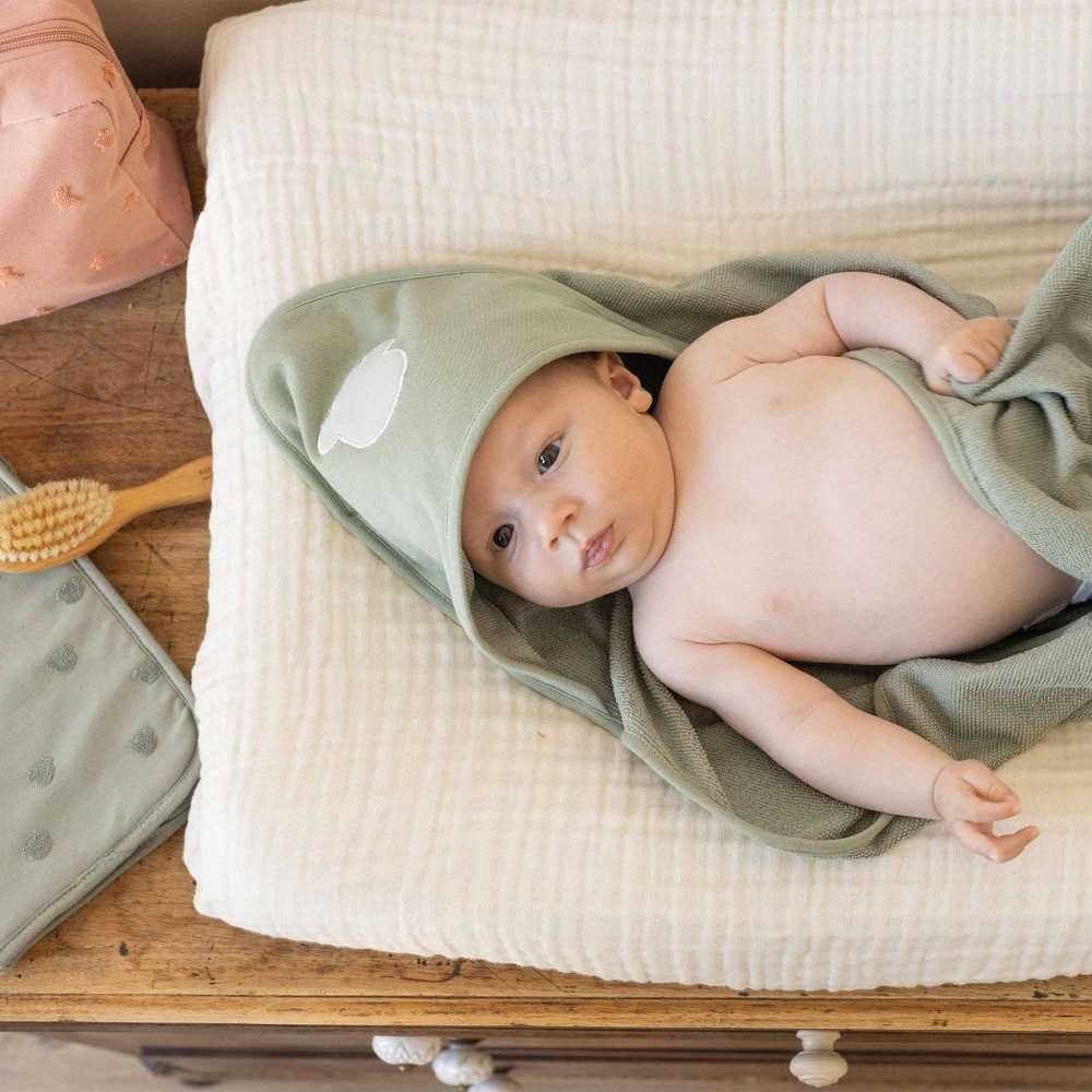 Baby auf Wickelunterlage mit seinem Baby-Badeumhang