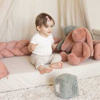 zittende baby met zijn decoratieve vlecht om zijn speelruimte te creëren