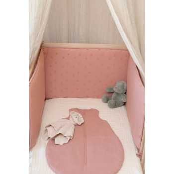 Inszenierung des Babyschlafsacks aus Musselin in einem Babybett