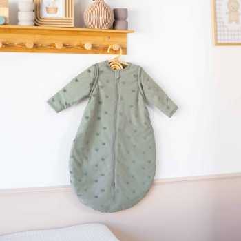 saco de dormir verde arcilla colgado en habitación de bebé