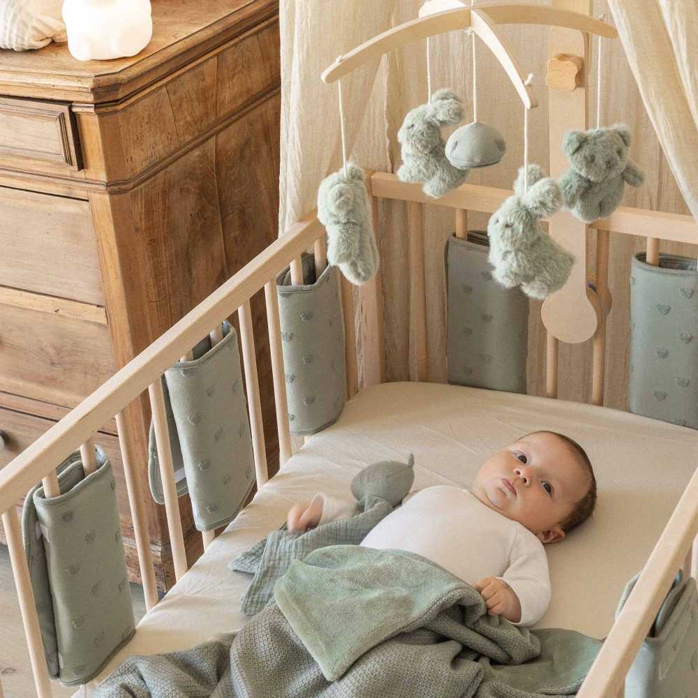 bambino nel suo lettino con paracolpi