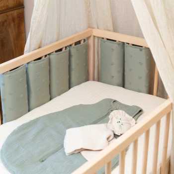 cuna de bebé con ropa de cama y protector de barrotes