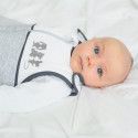 Blauäugiger Junge liegt in seinem Bett mit seinem Unisex-Neugeborenen-Schlafsack