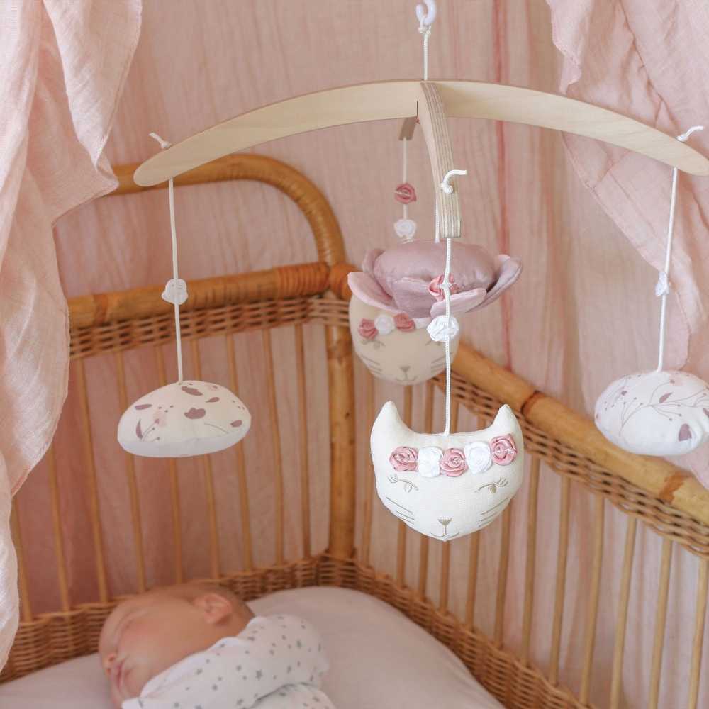 móvil musical encima de un bebé durmiendo en su cunita