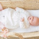 Baby das in seinem weißen Sophie la Girafe Pyjama-Kleid schläft