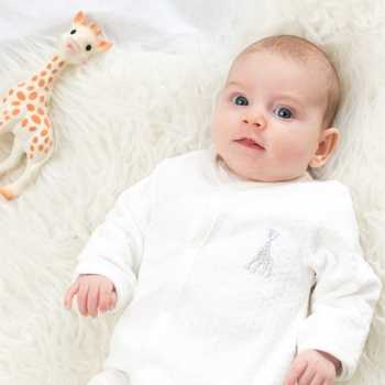 Baby in velour pajamas with her Sophie la Giraffe