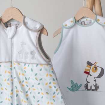 Deux gigoteuses bébé suspendues à des cintres en bois de la collection Kolala et sa tribu