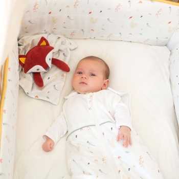 Baby in bed wearing a sleep sack with his fox comforter