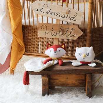 Doudou renard et doudou chouette sur un bac dans une chambre d'enfant