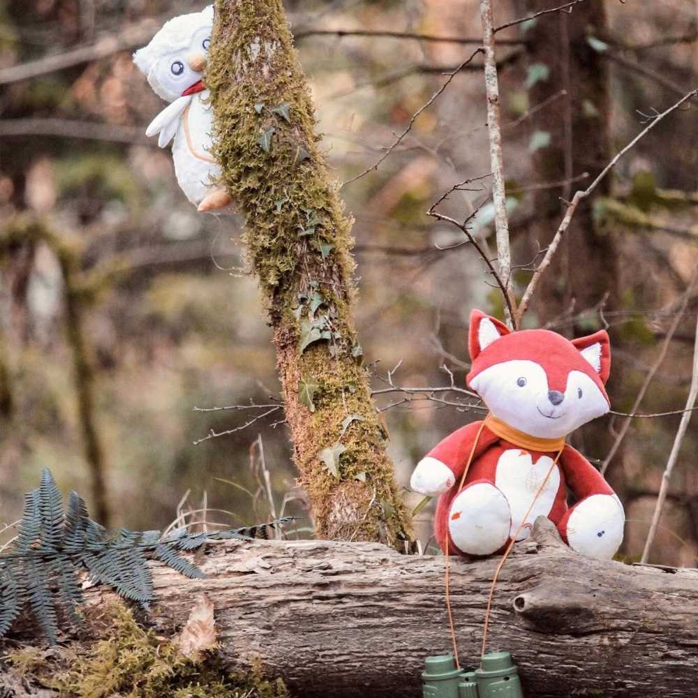 Peluche musicale chouette cachée derrière l'arbre pour observer le renard