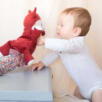 Een mama die poppenspel doet met de knuffel Léonard de vos