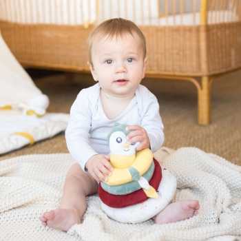 Bébé qui joue avec sa pyramide empilable douce avec son visage chouette