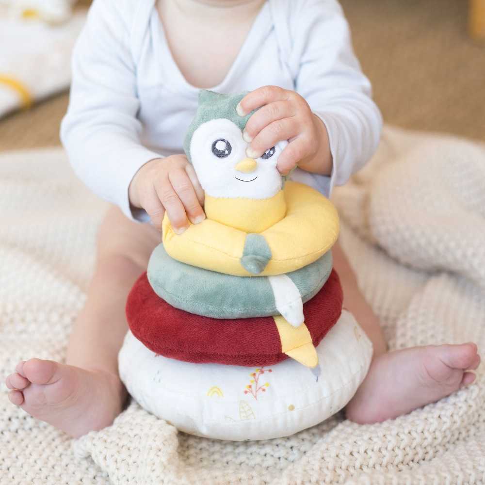 Bébé assis qui tient la pyramide empilable