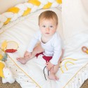 Bambina seduta sul suo tappetino gioco circondata dalla treccia decorativa