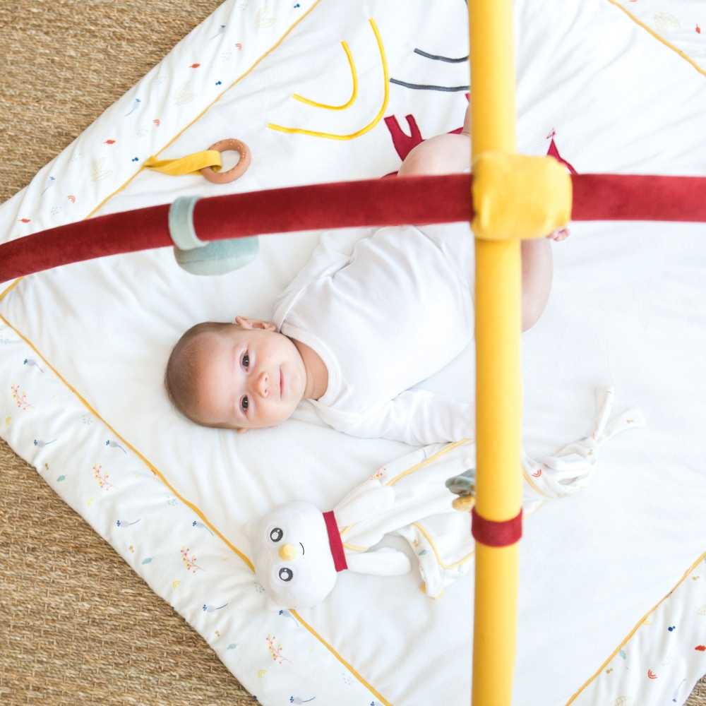 Bébé allongé sur son tapis avec arches