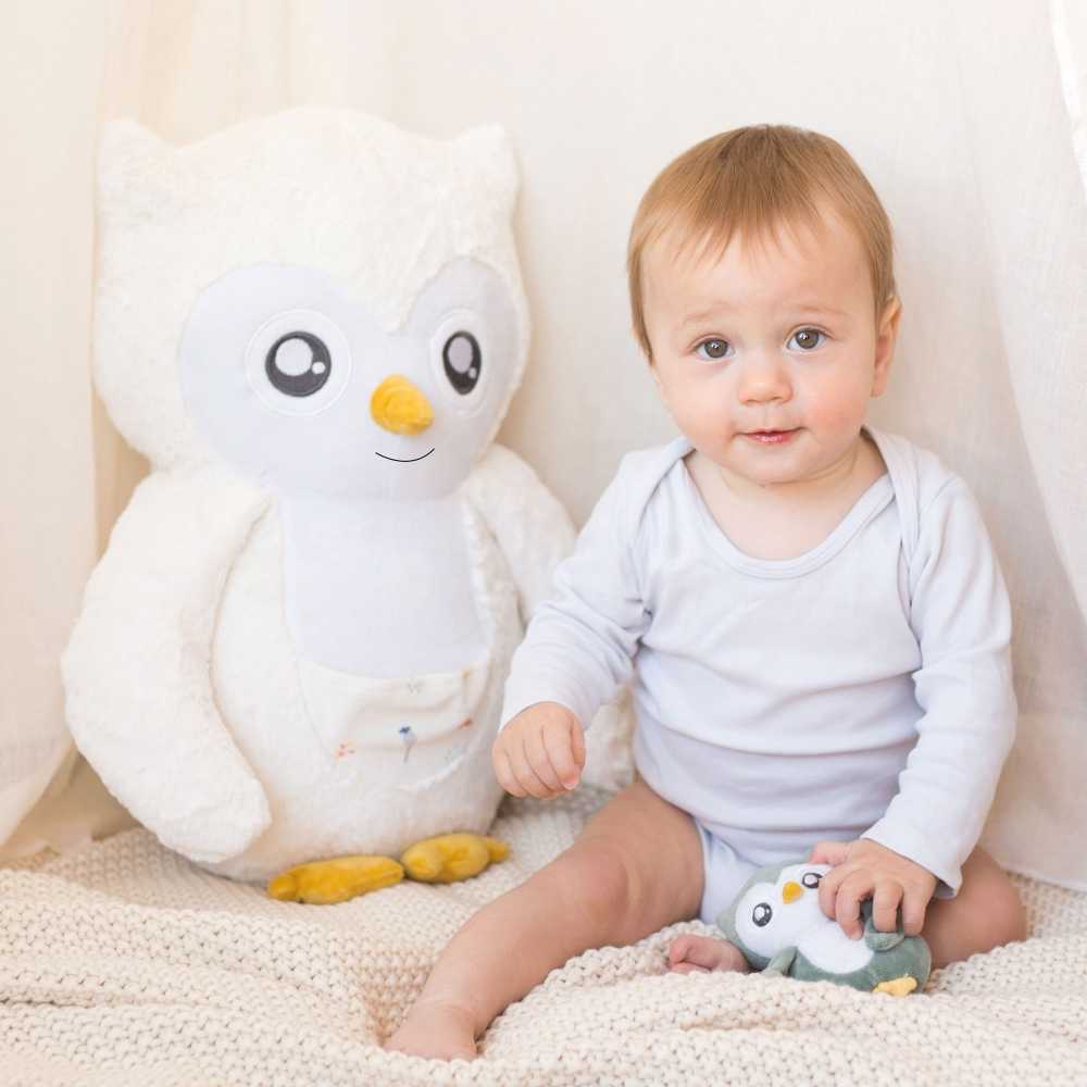 Peluche Violette à côté de bébé dans l'espace de jeu