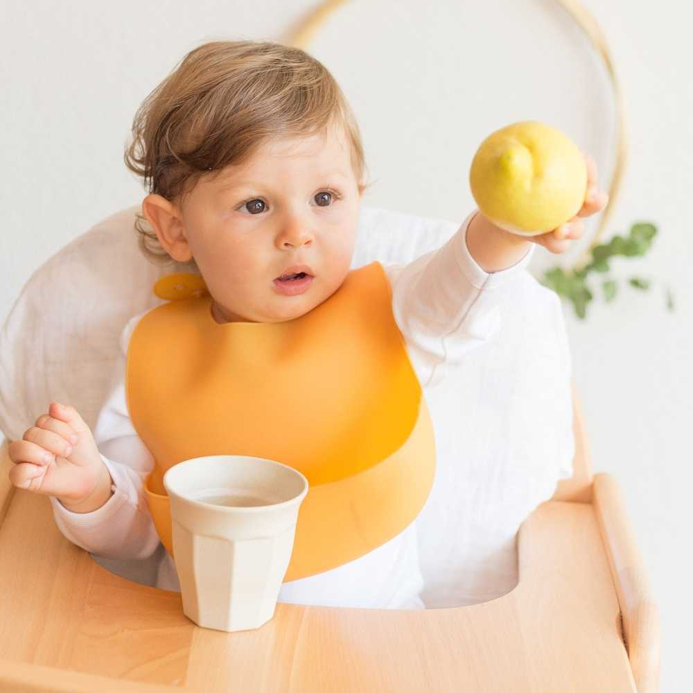 Baby aan tafel met zijn siliconen slabbetje