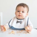 Baby bezig met het eten van zijn cake beschermd door zijn gentleman slabbetje