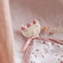 doudou rose posé sur le lit de bébé avec une petite fleur de décoration
