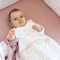 Baby lying down with its 90 cm sleeping bag on a white background printed with Floral - Rose & Lili