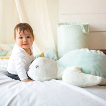 Baby with their big Manu the turtle plush toy