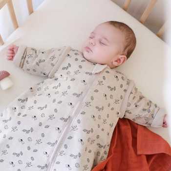 Baby die lekker warm slaapt in zijn bedje en in zijn bos slaapzak met mouwen