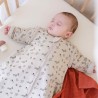 Bambino che dorme al caldo nel suo lettino e nel suo sacco nanna con maniche foresta