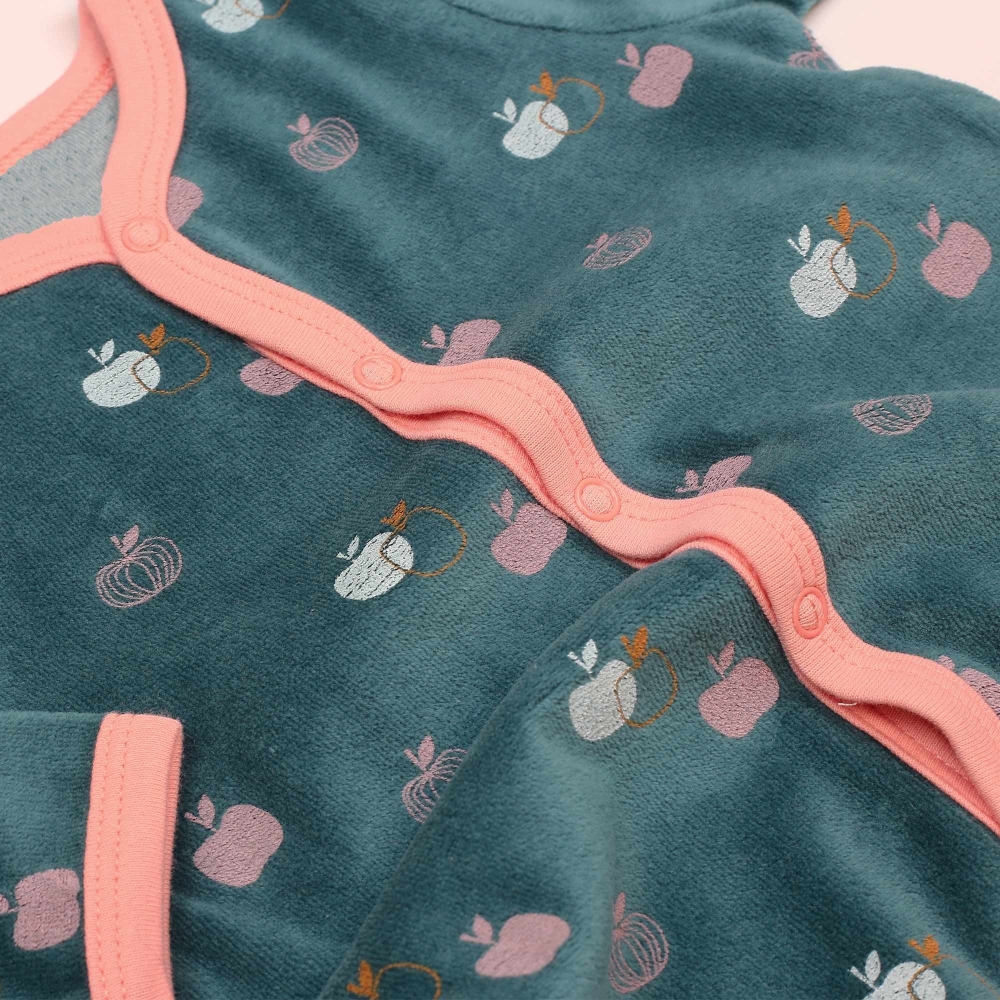Zoom sobre los motivos de manzanitas y la materia terciopelo del pijama