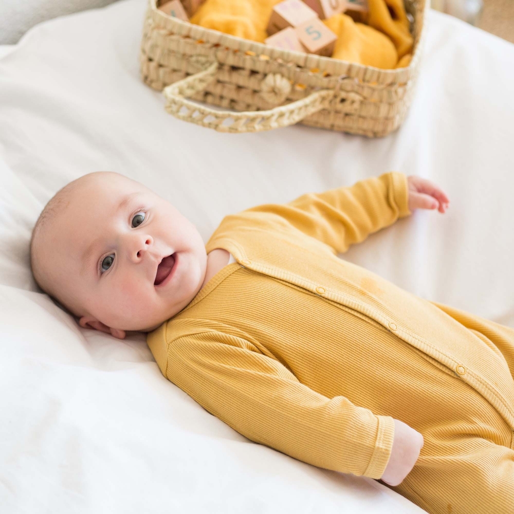 bébé dans son pyjama côtelé moutarde