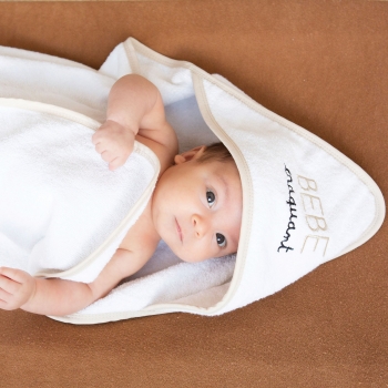 Bébé bien au chaud dans sa cape de bain sur son matelas à langer