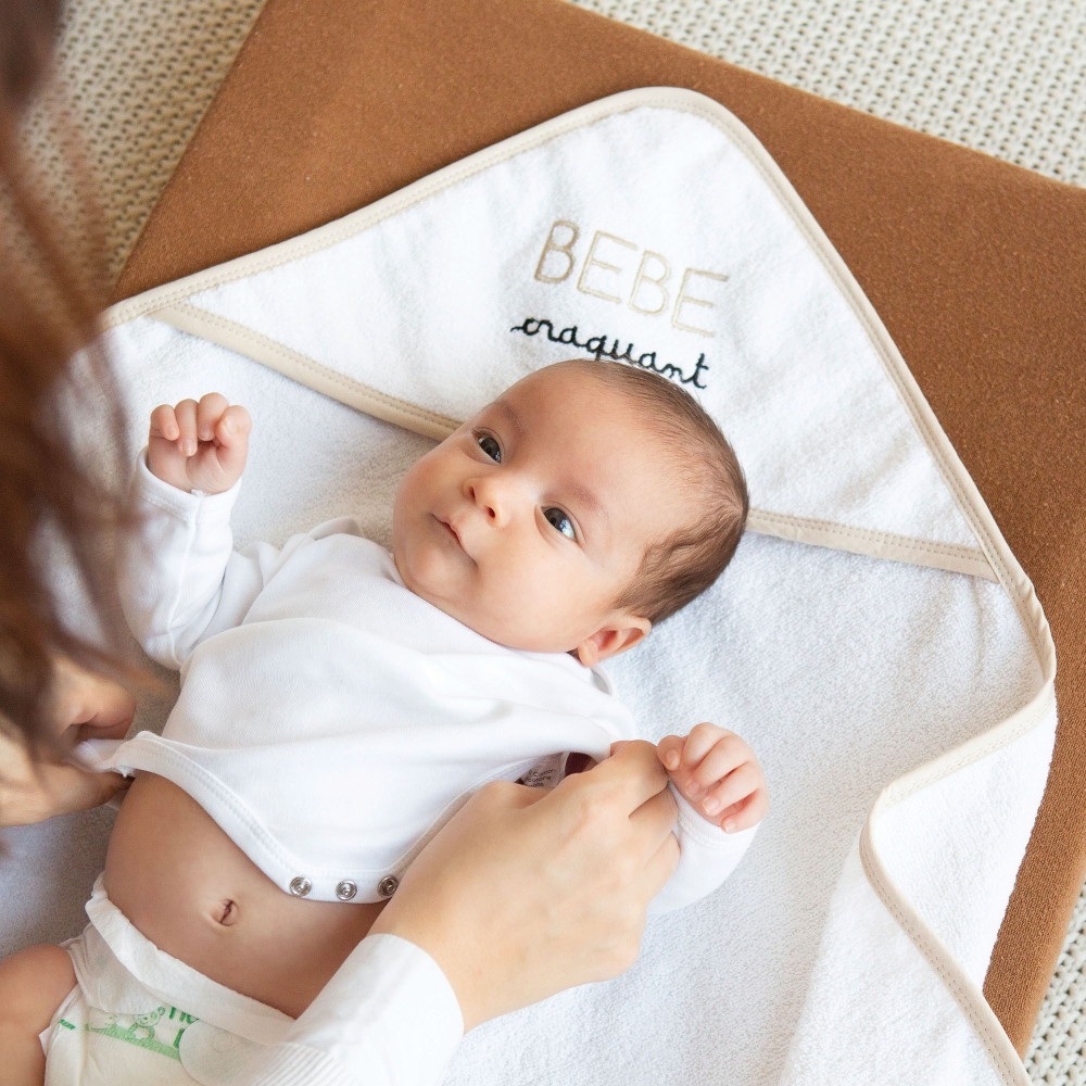Baby, das von seiner Mama auf dem Baby-Bademantel "süßes Baby" gewickelt wird