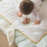 Baby looking at itself in the mirror of the activity mat