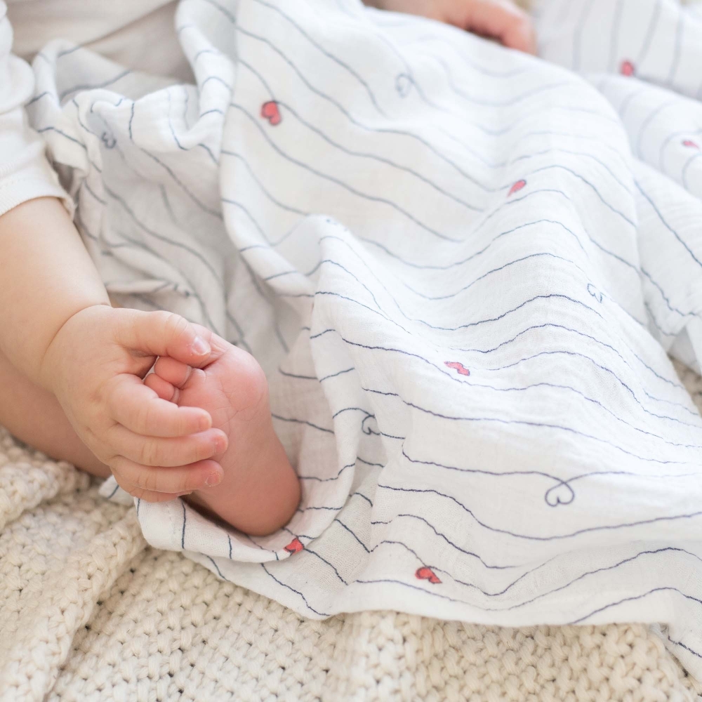 baby with muslin swaddles in sailor stripes
