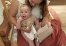 maman et son bébé qui jouent avec un doudou lion